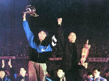 1995年上海申花拿下甲A冠军，范志毅和徐根宝举起奖杯庆祝