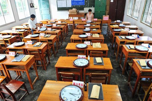 6月6日,在广西来宾市忻城县中学考点,工作人员在调校考场用的钟表.图片