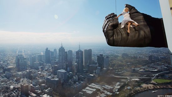 Woman held by a King Kong hand above Melbourne.