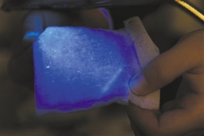 前日的实验中，在紫外分析仪下照射，路通小吃店的餐巾纸发出大片蓝色荧光。