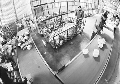 河北秦皇岛海港区临港物流园区一家快递公司内，快递员正在分拣快递包裹。