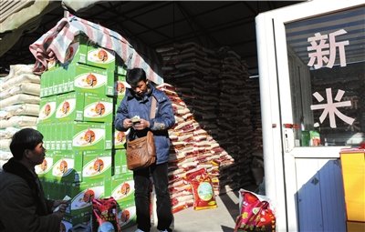 上周,北京锦绣大地粮油批发市场,顾客购买大米.大米价格近期持续上涨.