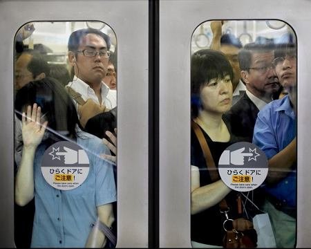 拥挤不堪东京地铁中人们的窘态