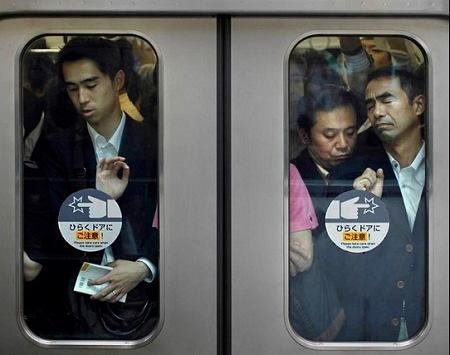 拥挤不堪东京地铁中人们的窘态