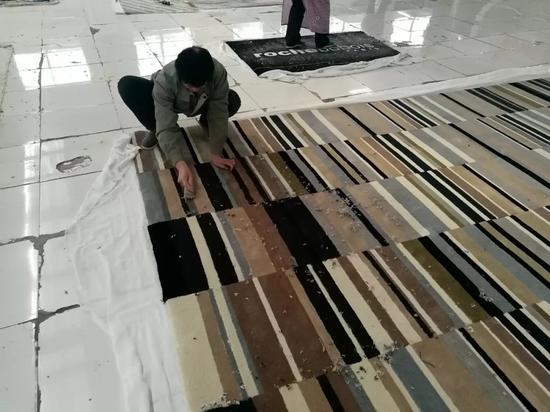 挂胶工人们需要把毯子清理干净后,用刷子把胶体一道一道涂抹在毯背上,这种技术要掌握‘火候’,不能厚薄不均,也不能涂出布边,更不能有漏胶。这些机器可能连碰都碰不了。