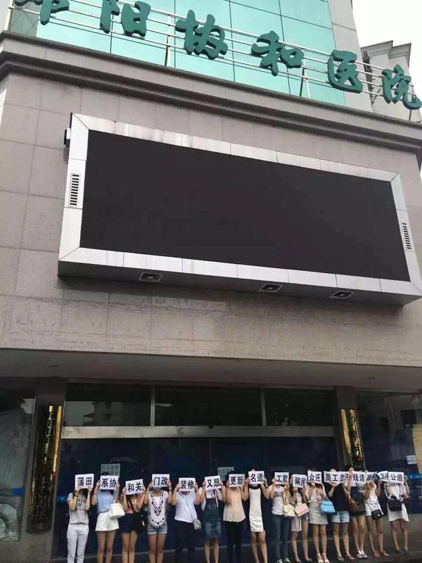 十几位女子遮住面部，站在绵阳协和医院门口。 绵阳微生活圈微信公众号 图