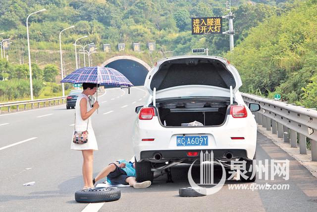过路车辆轮胎被扎破,车主不得不停车换轮胎,非常危险.-面包车高高清图片