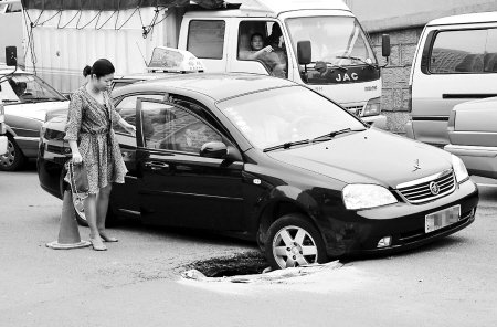 路中央深坑刚填上又塌 咬车轮不放