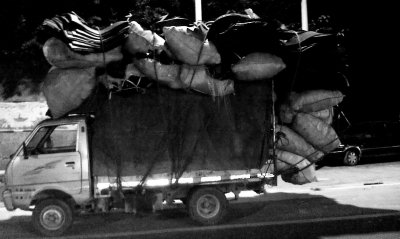 麻袋包超高超长将车牌遮挡 货车司机被罚款扣