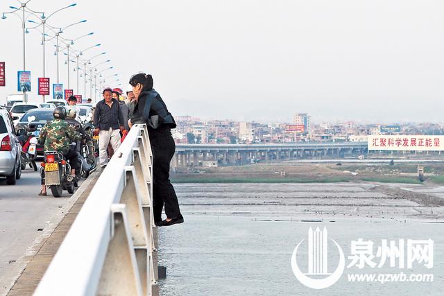 吴嘉晓/图)昨日下午5时许,后渚大桥上,一名女子站到大桥栏杆外侧,欲跳