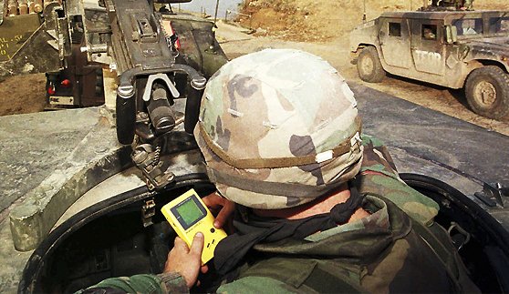 1996年10月15日,萨拉热窝北部的奥拉谢,一名美军士兵在悍马军车顶部玩掌机。
