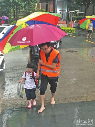 校长暴雨中脱鞋站岗迎学生 家长义工赤脚接幼