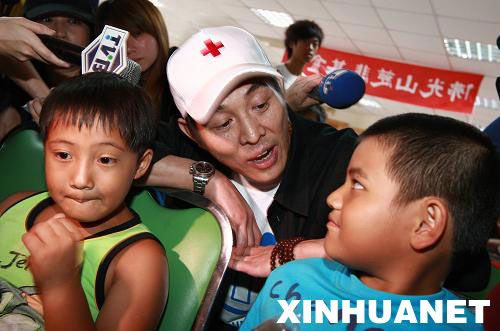 8月15日,李连杰(中)在台湾高雄县旗山镇灾民收容所,与高山族小朋友共唱《我们是一家人》。