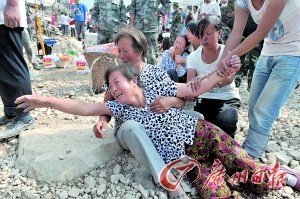 女人们悲痛地哭喊着被埋在泥土下面的家人的名字.