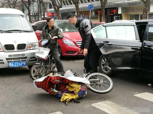 武汉一小车开车门撞倒电动车 骑车男子头破血