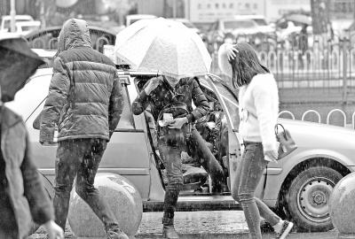 昨天下午，在汉口解放大道武广门前，乘客冒雨争“抢”出租车记者喻志勇 摄
