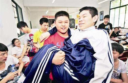 武汉残疾生获同窗照顾3年 学校为他没换过教室