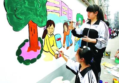 武汉小学生室外上美术课 绘水彩装点近百米长