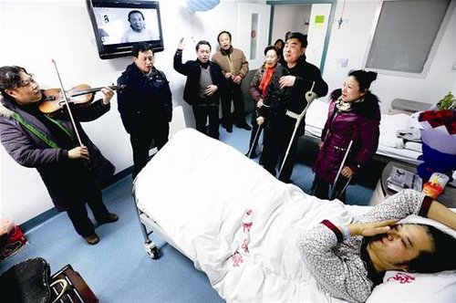 图为:病房内响起“只要人人都献出一点爱,世界将变成美好的人间”的歌声,袁春生泪流满面