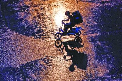 图：昨天入夜时分，汉口一带大雨倾盆，一位外卖送餐员冒雨送餐。记者 喻志勇 摄
