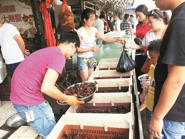 图为:在华南海鲜市场,记者看到很多人买小龙虾