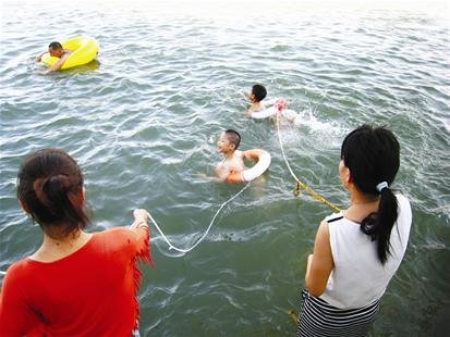 武汉家长不放心小孩游泳 水中放起风筝(图)