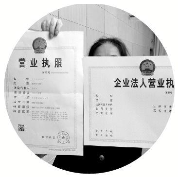 工商人员展示新版营业执照样本.本报记者