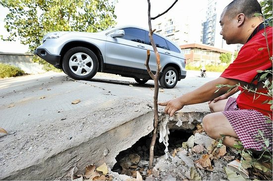 水泥马路受热拱起 过往小轿车底盘频被刮高清图片