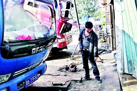 司机停车未挂空挡 货车自己启动撞破维修店门