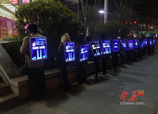 郑州街头现夜光人体广告 寒风中背电子广告牌