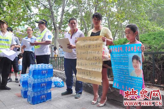 8月18日，来自南阳南召的李兴举夫妇在向过往的市民发放寻人启事，让大家帮忙寻找离家半个月的儿子。