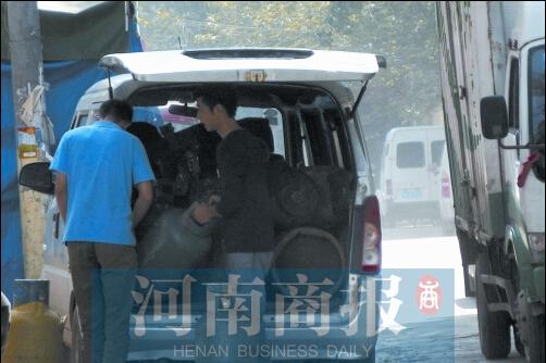 男子餐馆内给液化气灌充气 旁边烟头火星滴落