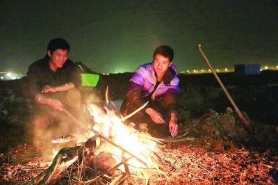 两大学生饭量大生活费不够用 春节守工地挣钱