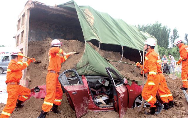 渣土车闯红灯翻车 小轿车被砸扁女司机身亡(图)