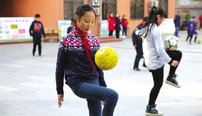 郑州小学生课间做足球操 女孩子玩起足球照样