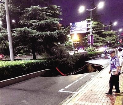 郑州暴雨中道路塌方 行人坠入坑中救援正在进行中