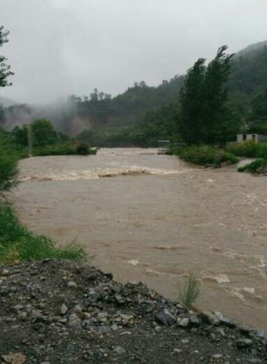 新乡辉县大雨形成洪水 多辆大货车被困在中间