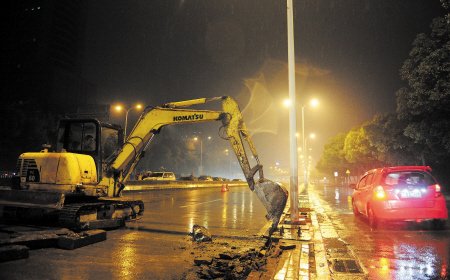 昨日,挖掘机正在东南二环线冒雨施工,力争如期完成路面整治及绿化带
