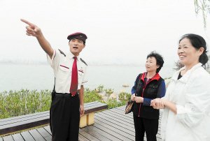 梅溪湖广电物业的工作人员为游玩的市民热情指路. 石祯专摄