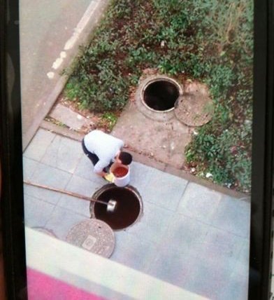 有人在下水道舀油? 学校辟谣:在清理下水道