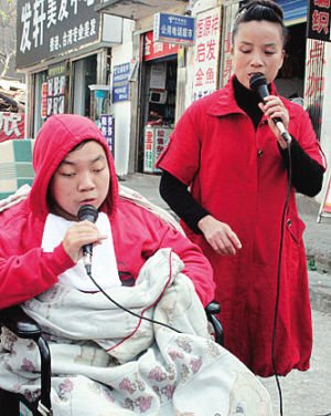 图为：母子在西安街头唱歌场景。来源：每日新报
