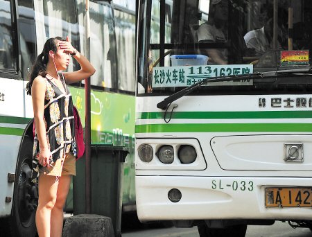 昨日中午,长沙火车站停车坪内,市民在烈日下等公交车.