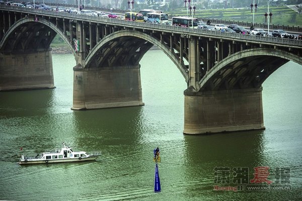 男子骑自行车跨越湘江 25米高空588米钢丝(图)