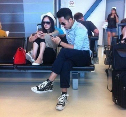 照片中杨幂抱膝团坐,穿着鞋子直接踩踏候机厅座