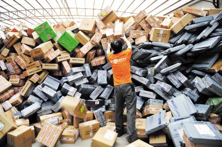 11月11日,在圆通公司广州一处分拣站,工作人员加紧处理堆积如山的快件。新华社发