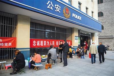 10月13日,通州北苑,群众搬着小马扎,在派出所门口排队办理居住证