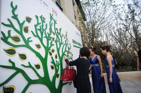 签到处更是别出心裁,嘉宾将名字签在绿色的树叶上,再粘贴至签名墙上的