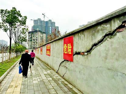 百米危墙上钉了23个警示牌