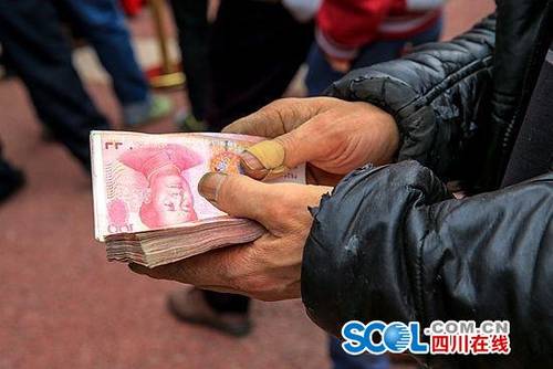 千万元码出"钞票墙" 泸州老板让农民工"提钱"过年