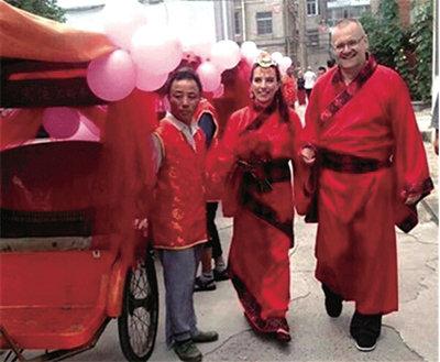 洋情侣泰州办中式婚礼 穿中国红汉服坐三轮车